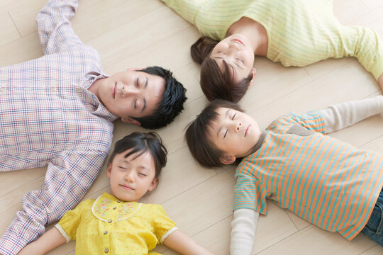 輪になって寝そべる4人家族