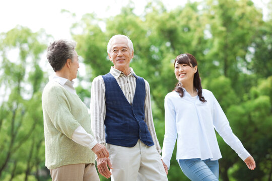 散歩をする寄り添う老夫婦と娘