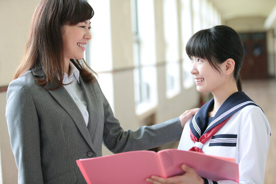 廊下で話をする先生と女子校生