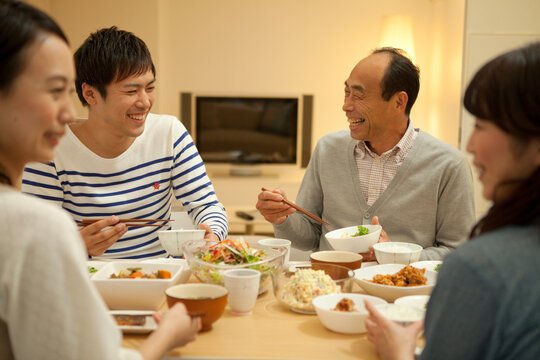 夕食をとる家族4人