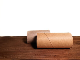 Two cardboard cylinders. Background with wooden floor and white color wall.
