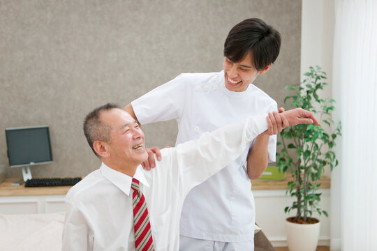 笑顔のマッサージ師とシニア男性