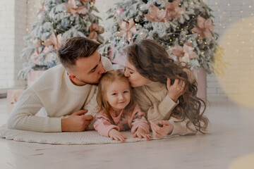 The theme of Christmas and New Year. Parents and children at home play under the Christmas tree. Joyful laughter and emotions. Christmas 2022.