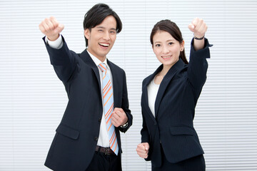 ガッツポーズをするビジネスマンとビジネスウーマン
