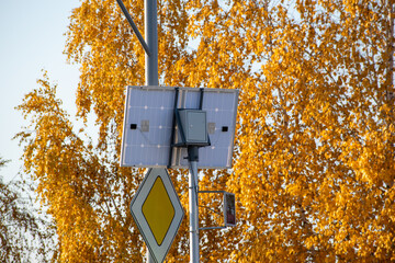 Background of yellow autumn leaves. Solar panels from the back against