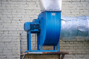 On the background of a brick wall. Supply and exhaust ventilation turbine with electric motor
