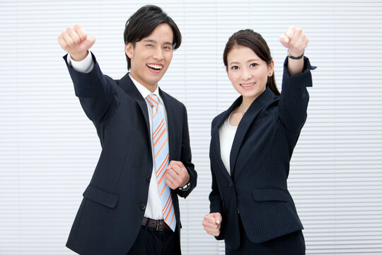 ガッツポーズをするビジネスマンとビジネスウーマン