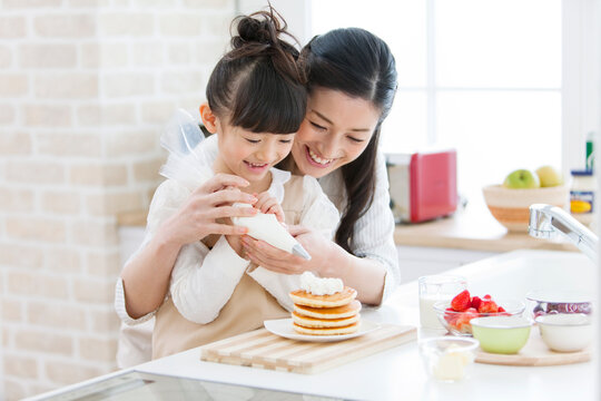 ホイップクリームを絞る女の子と母親