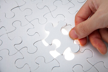 パズルのピースをはめる手