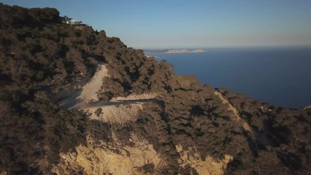 Extreme mountain biking trail by cliffs in Ibiza, Es Vedra, drone aerial