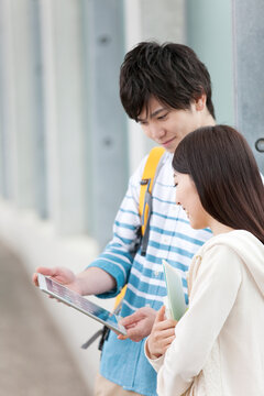 タブレットPCを見る大学生カップル