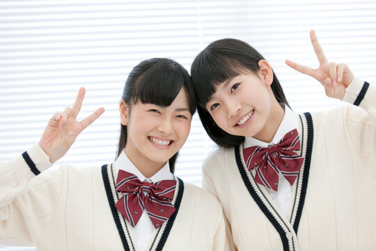 Vサインをする女子校生2人