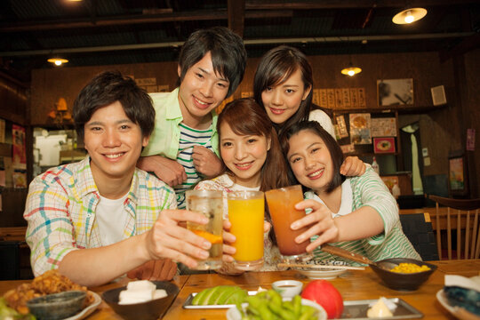 居酒屋で乾杯をする若者5人