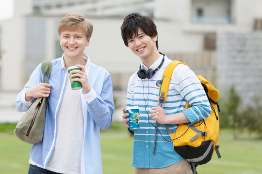 コーヒーカップを持つ男子学生2人