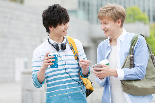 スマートフォンを持つ男子学生2人