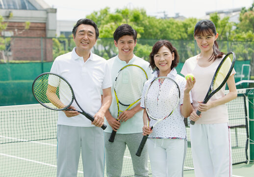 テニスコートに立つ男女4人
