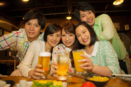 居酒屋で乾杯をする若者5人
