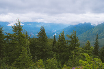 View of Fraser River valley mountains from the Nahatlatch Fire Lookout on a cloudy day, lush green forest and mist