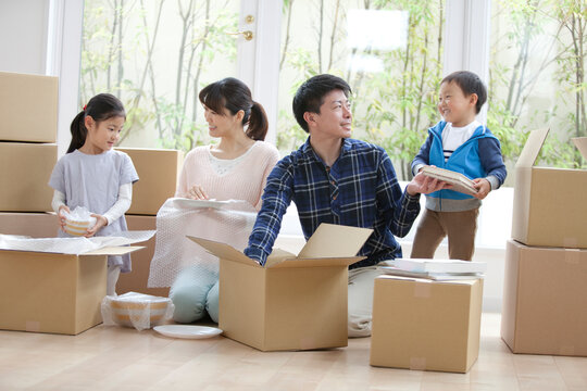 引っ越しの荷造りをする家族4人