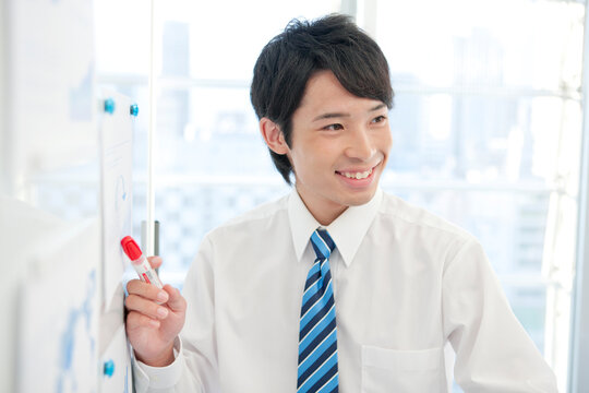 ホワイトボードの前に立つビジネスマン