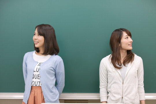 黒板の前に立つ学生2人