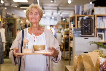 Fototapeta na wymiar Senior woman client consumer choosing variety goods for kitchen at store