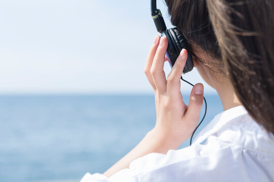 ヘッドホンで音楽を聴く女性