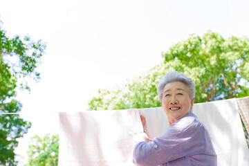 洗濯物を干すシニア女性