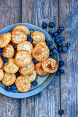 Homemade Dutch Poffertjes  Mini Pancakes with butter , Powdered Sugar  and blueberries