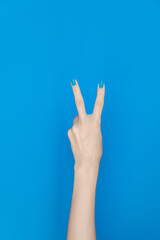 hand showing number two In front of the blue background
