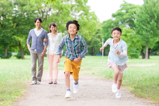 走る兄妹と腕を組んで歩く両親