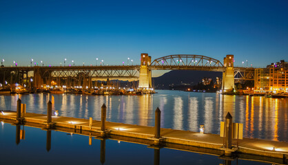 Naklejka premium Night view of Granville Bridge at twilight time. Wooden pier with night lights on a river.