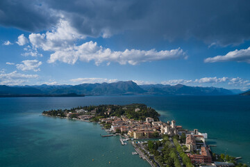 Sirmione, Lake Garda, Italy. Castle on the water in Italy. Aerial view of the island of Sirmione. Panorama of Lake Garda. Peninsula on a mountain lake in the background of the alps.