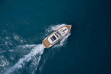 Luxury yacht on the water aerial view. White yacht fast movement on the water top view. Travel -...