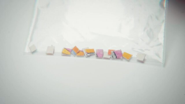 4K macro footage of micro doses of acid tabs of LSD in a plastic bag.
