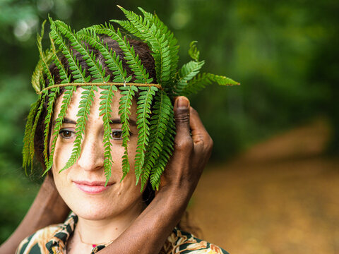 portrait of a happy caucasian woman in the autumn forest with a crown of ferm