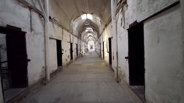 Moving shot of prison corridor past cells at Eastern State Penitentiary.