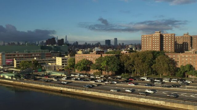 very fast reversing pan across the Harlem River Drive in New York City with view of Midtown in the distance and a housing project nearby