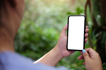 Close up view female holding mock up mobile phone with blank screen.	