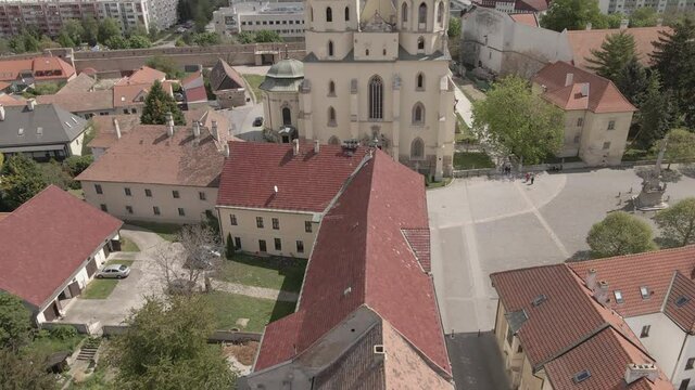 Historical church in Trnava city surrounded by historical buildings.