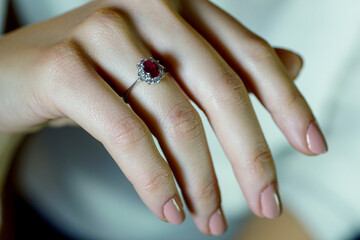 Red stone ring, diamond ring with red stone on girl finger, macro close up  photo