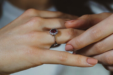 Red stone diamond ring, diamond ring with red stone on finger, macro close up photo