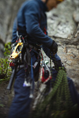 Climber works with a rope during the ascent, unsharp silhouette, close-up.