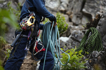 Climber works with a rope during the ascent, face is not visible.