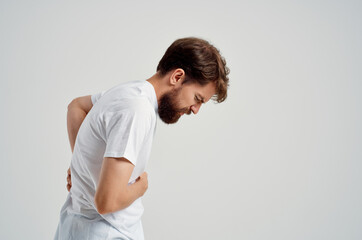 emotional man in a white t-shirt stress medicine backache studio treatment