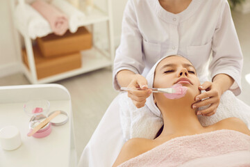 Calm relaxed beautiful young lady lying on soft towel in beauty parlor or spa salon for women and...