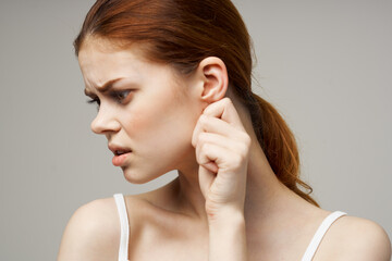 sick woman ear pain health problem dissatisfaction light background