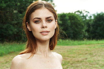 beautiful woman in a field outdoors bare shoulders clear skin cropped view