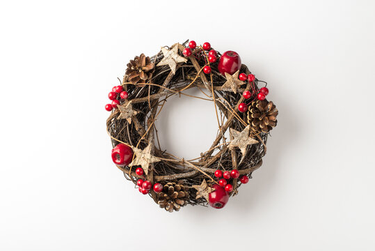 Top view photo of christmas twig wreath with holly berries and pine cones on isolated white background with copyspace
