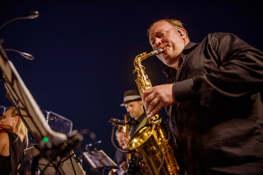 Male Musician Playing Saxophone Under Blue Night Sky